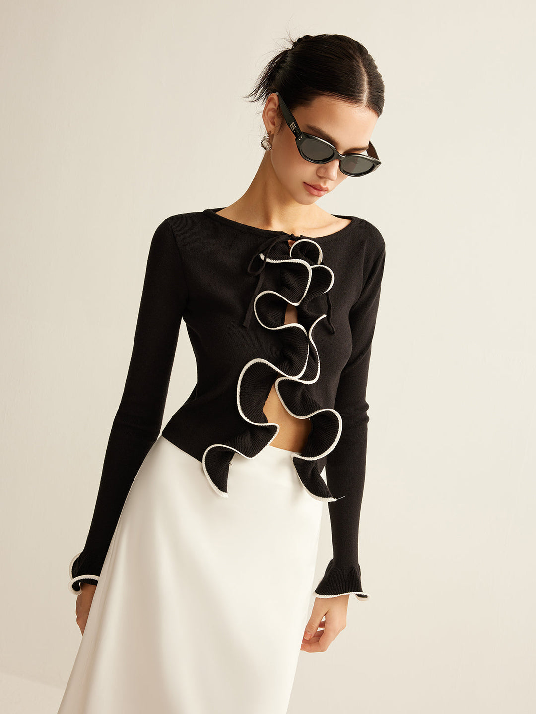 Women's black skinny ruffle cardigan. Elegant & fashionable slim-fit top for versatile layering.
