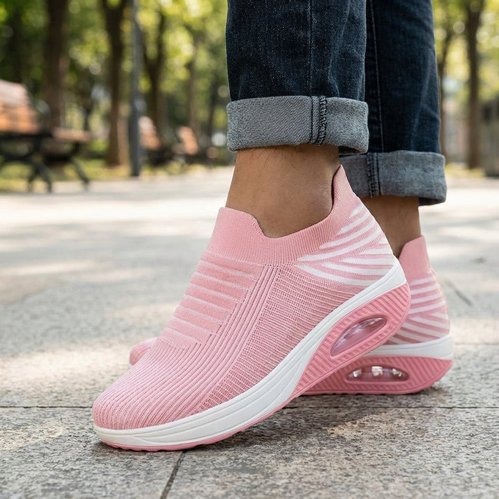 Women's black slip-on wedge sneakers with knitted upper, comfortable for everyday wear.