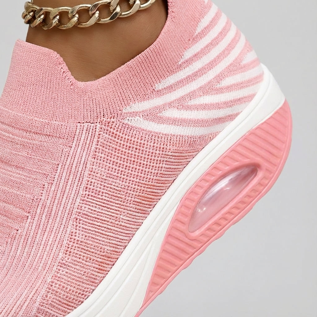 Close-up of comfortable women's slip-on wedge sneaker showing knitted texture and sole.