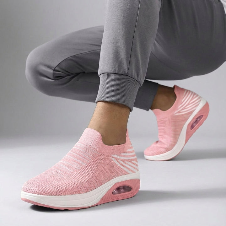Side view of women's casual slip-on wedge sneakers with a flexible knitted upper.