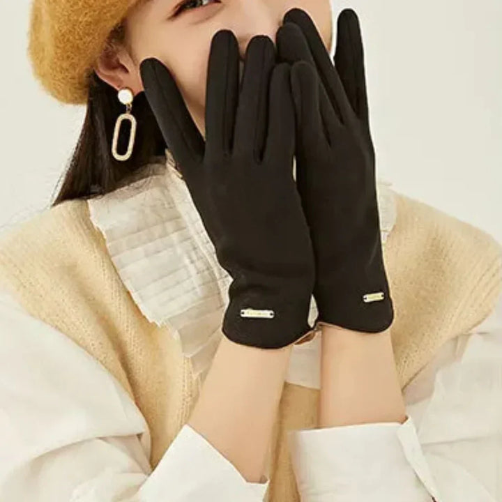Woman's hand in fashionable green suede cashmere gloves, effortlessly using a mobile device
