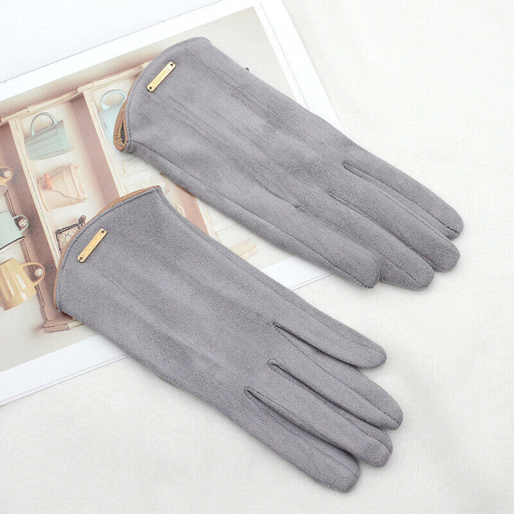 Close-up of a woman's hand wearing red suede cashmere gloves, showcasing touchscreen finger
