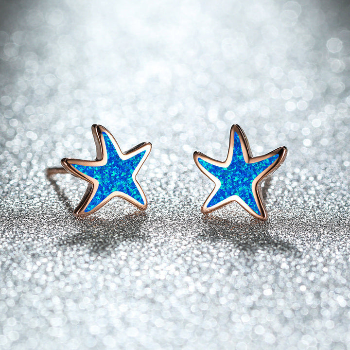 Pair of blue opal starfish earrings, delicate and shimmering, ideal for sea lovers.