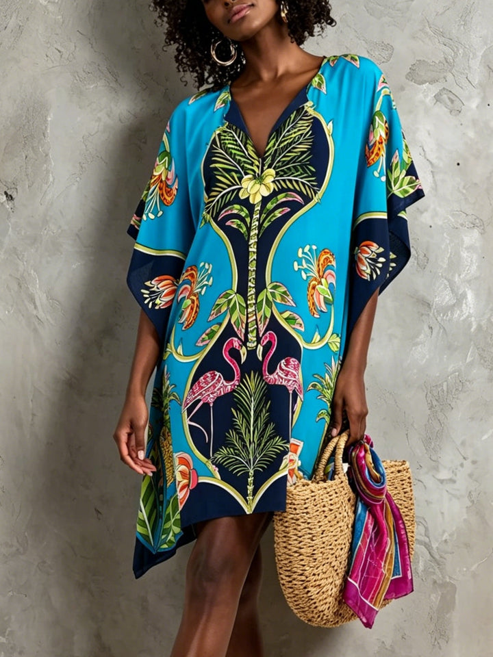 Women's blue tropical midi dress with V-neck, batwing sleeves. Perfect for resort wear & summer beach vacations.