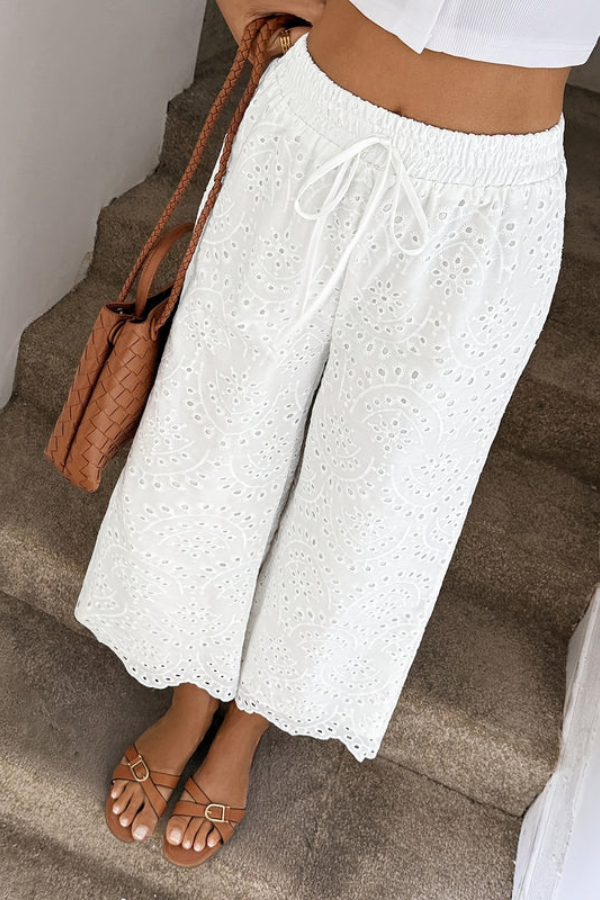 Stylish women's cropped eyelet summer pants in boho style, ideal for relaxed vacation wear.