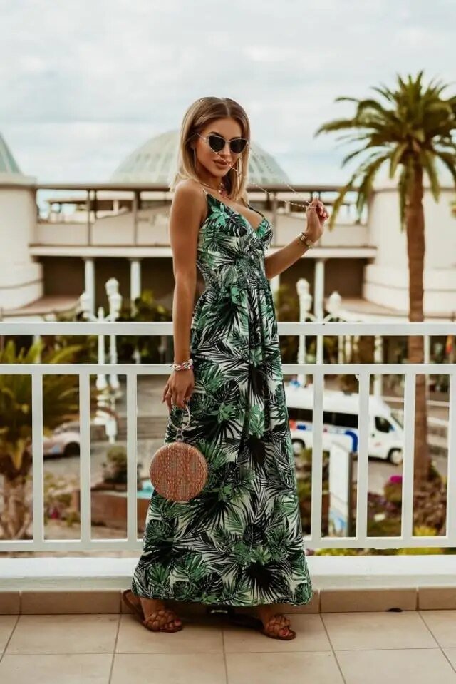 Full length view of a woman wearing a vibrant floral bohemian maxi dress outdoors