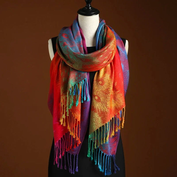Women's Bohemian peacock shawl with vibrant red & blue print, long fringe. Elegant, versatile fashion accessory.