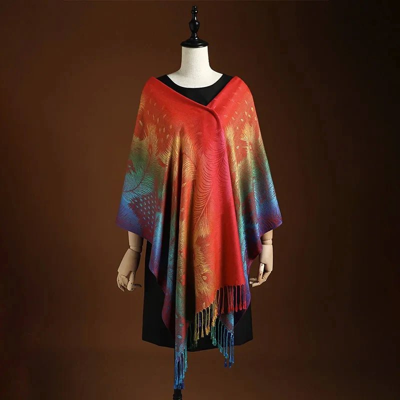 Close-up of a women's Bohemian peacock shawl with detailed pattern & flowing fringe. Stylish red & blue accessory.