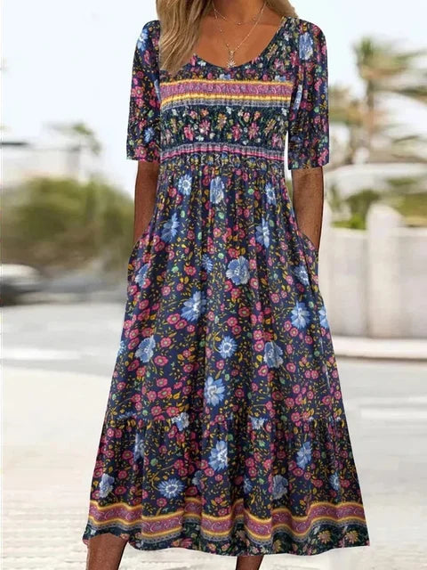 Woman in an elegant boho print midi dress, featuring a gathered waist, short sleeves, and discreet pockets.