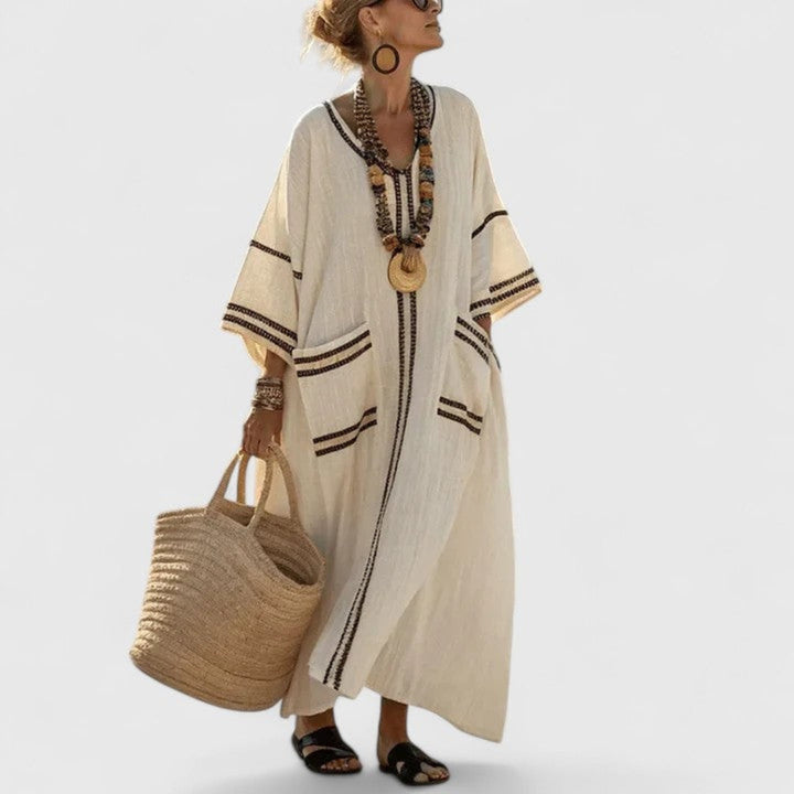 Casual women's striped maxi dress featuring a stylish V-neckline and convenient side pockets. Perfect beach kaftan.