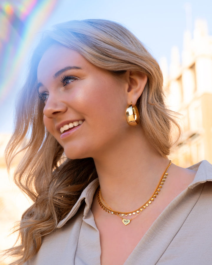 Close-up of elegant women's bold statement hoop earrings in gold & silver. Quality design.