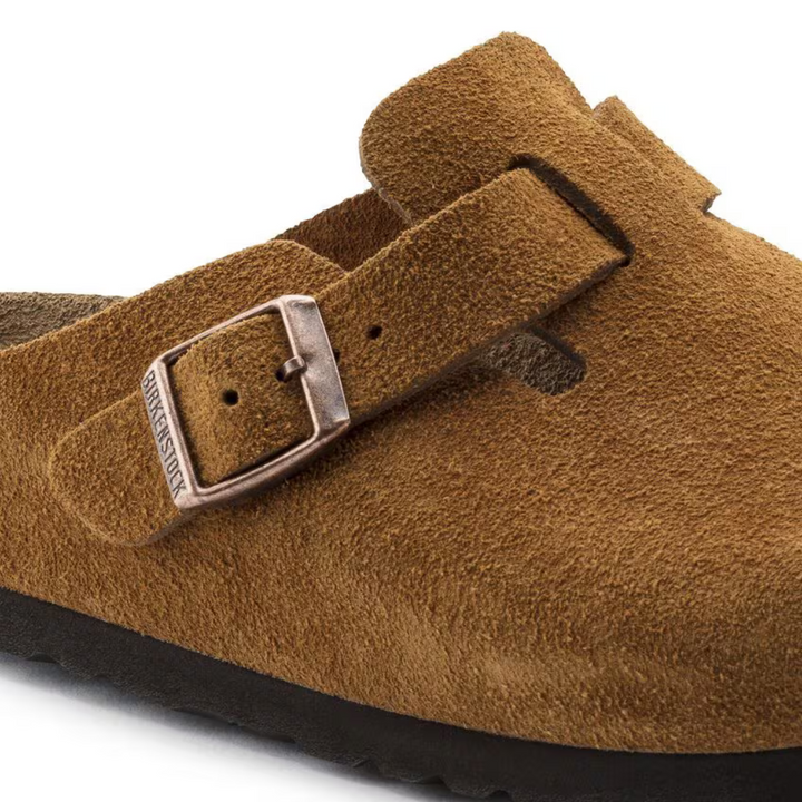 Woman walking in comfortable taupe Boston clogs, demonstrating everyday arch support and casual style.