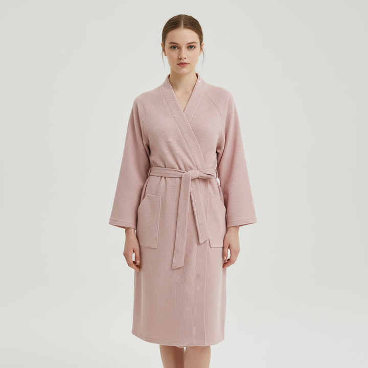 Folded women's breathable soft comfort bathrobe in light pink, stylish spa or nightwear