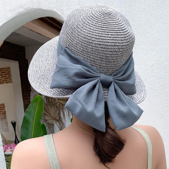 Women's breathable summer sun hat in a wide brim style with an elegant bow detail, perfect for beach wear.