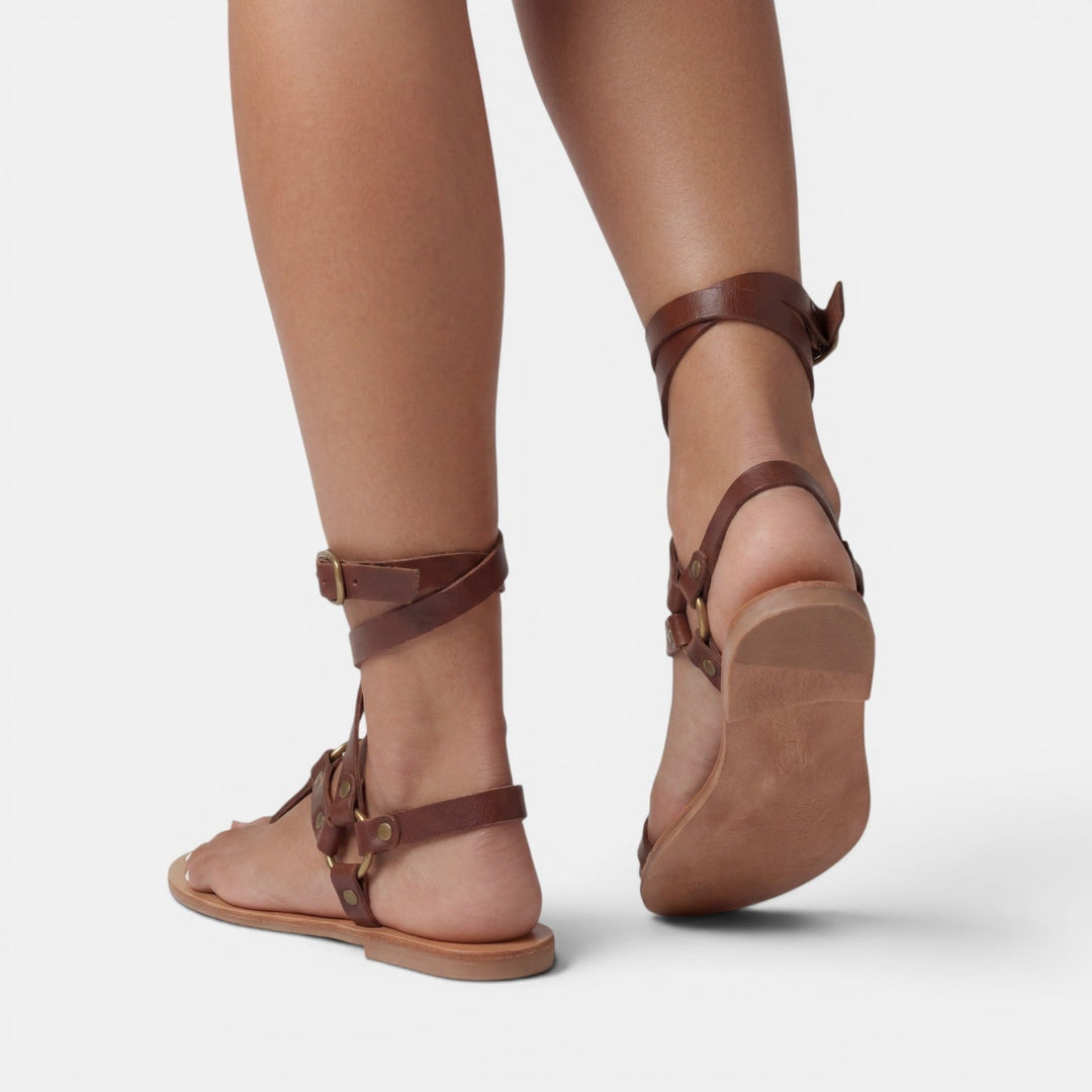 Stylish buckled flat sandals for women, showcasing a trendy snake print and comfortable crossover straps.