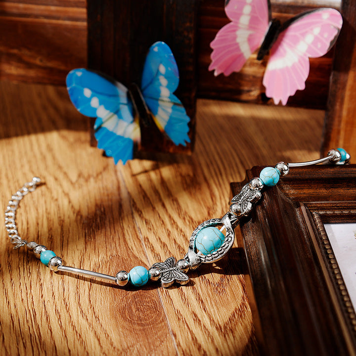 Intricate butterfly and turquoise beaded bracelet for women, featuring adjustable silver jewelry design.