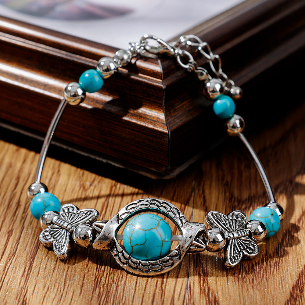 Stylish women's turquoise beaded bracelet featuring delicate silver butterflies, an ideal adjustable gift.