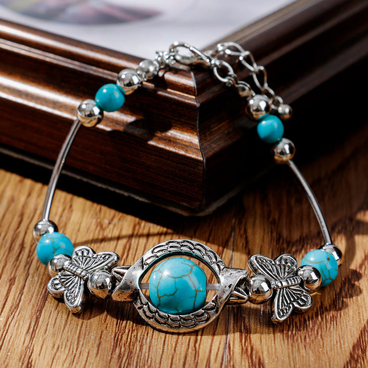 Stylish women's turquoise beaded bracelet featuring delicate silver butterflies, an ideal adjustable gift.