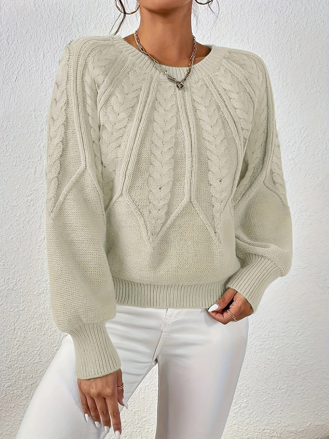 Close-up: Women's cable knit sweater texture, showing relaxed fit and elegant lantern sleeve detail.