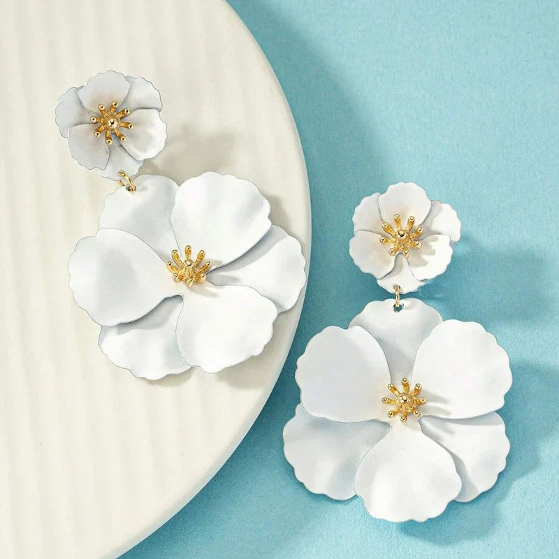 Close-up of gold plated cascading double flower earrings for women, intricate floral design.