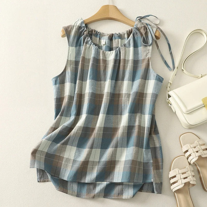 Relaxed fit women's sleeveless blouse featuring a chic checkered pattern & tie neck detail.