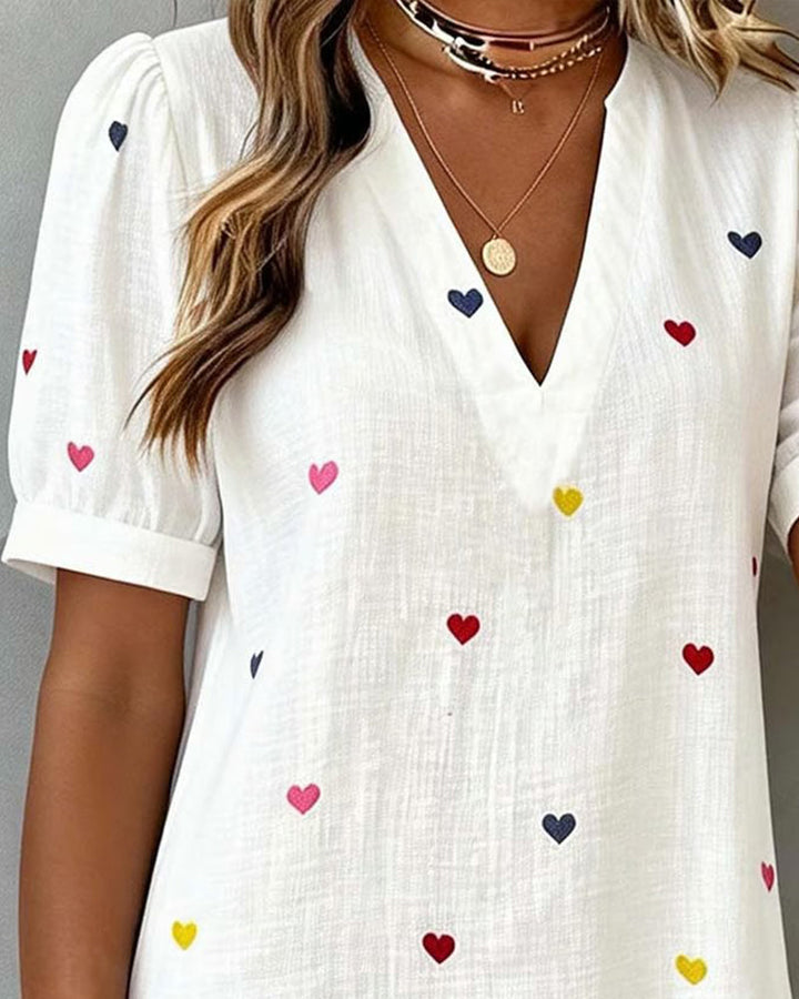 Summer women's mini dress in a vibrant heart print. Comfortable casual style with a flattering V-neckline.