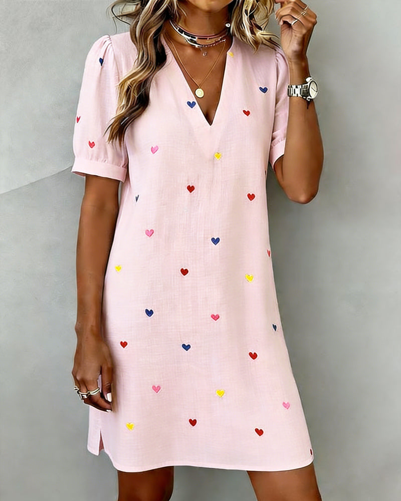 Stylish women's mini dress with all-over heart print, V-neck, and trendy puff sleeves, great for casual outings.