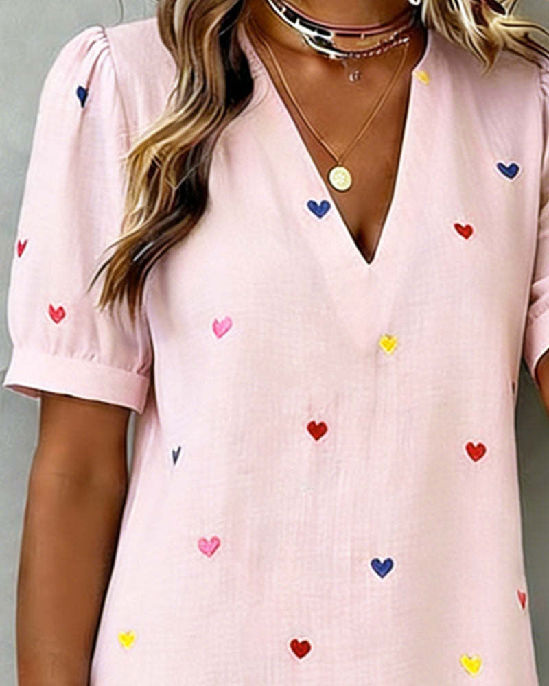 Close-up of the soft fabric and adorable heart print on this comfortable women's casual mini dress with puff sleeves.