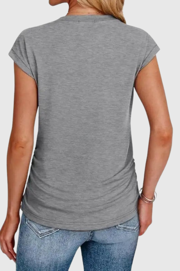 Relaxed fit women's tunic blouse, featuring stylish ruched sides & short ruffle sleeves. Versatile top.
