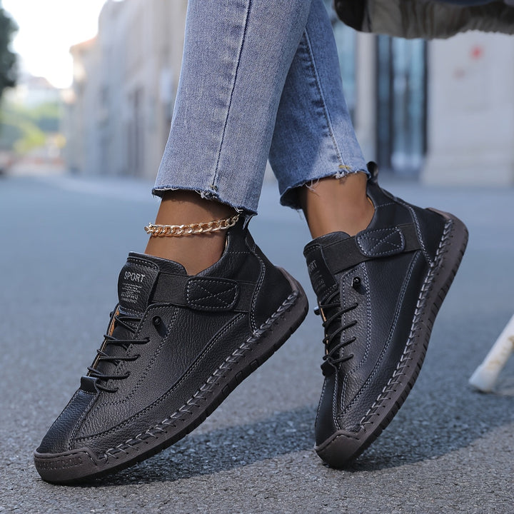Fashionable women's low-top sneakers featuring elegant stitched details & secure lace-up closure for casual wear.