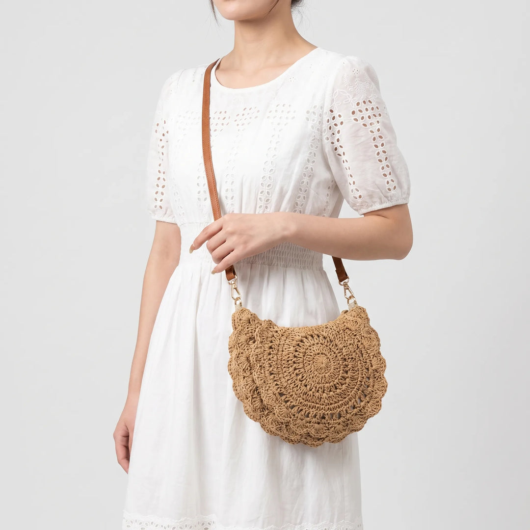 Vintage style woven women's crossbody bag featuring a distinctive scalloped flap and adjustable strap.