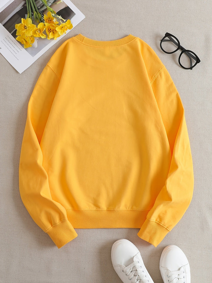 Cozy women's yellow sweatshirt featuring a humorous graphic print. Soft long-sleeve top for casual winter style.
