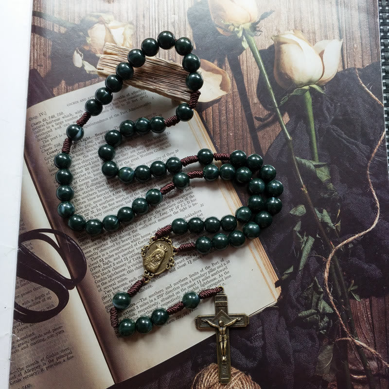 Close-up of a women's moss agate rosary necklace, highlighting the cross and holy medal pendant details.