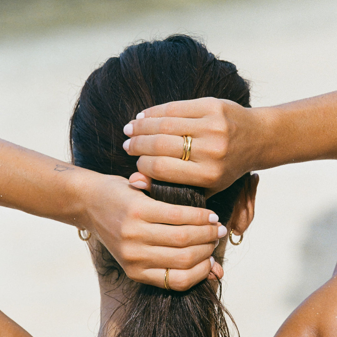 Close-up of women's gold & silver celestial stackable rings, intricate design. Fashion-forward, durable.