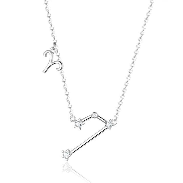 Woman's neck adorned with a delicate gold plated celestial zodiac necklace.