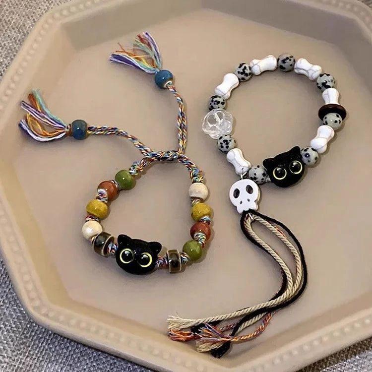 Edgy-cute women's ceramic charm bracelet. Features kitten & skull motifs with bohemian fringe accents.