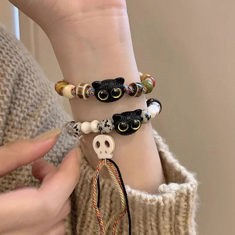 Women's handmade bohemian bracelet. Ceramic kittens, skull, & fringe charms for a unique jewelry style.