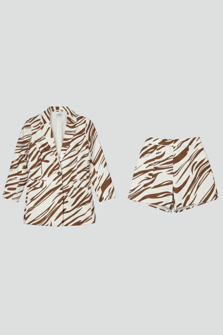 Close-up of animal print fabric on women's blazer & shorts co-ord set. Detailed chic style.