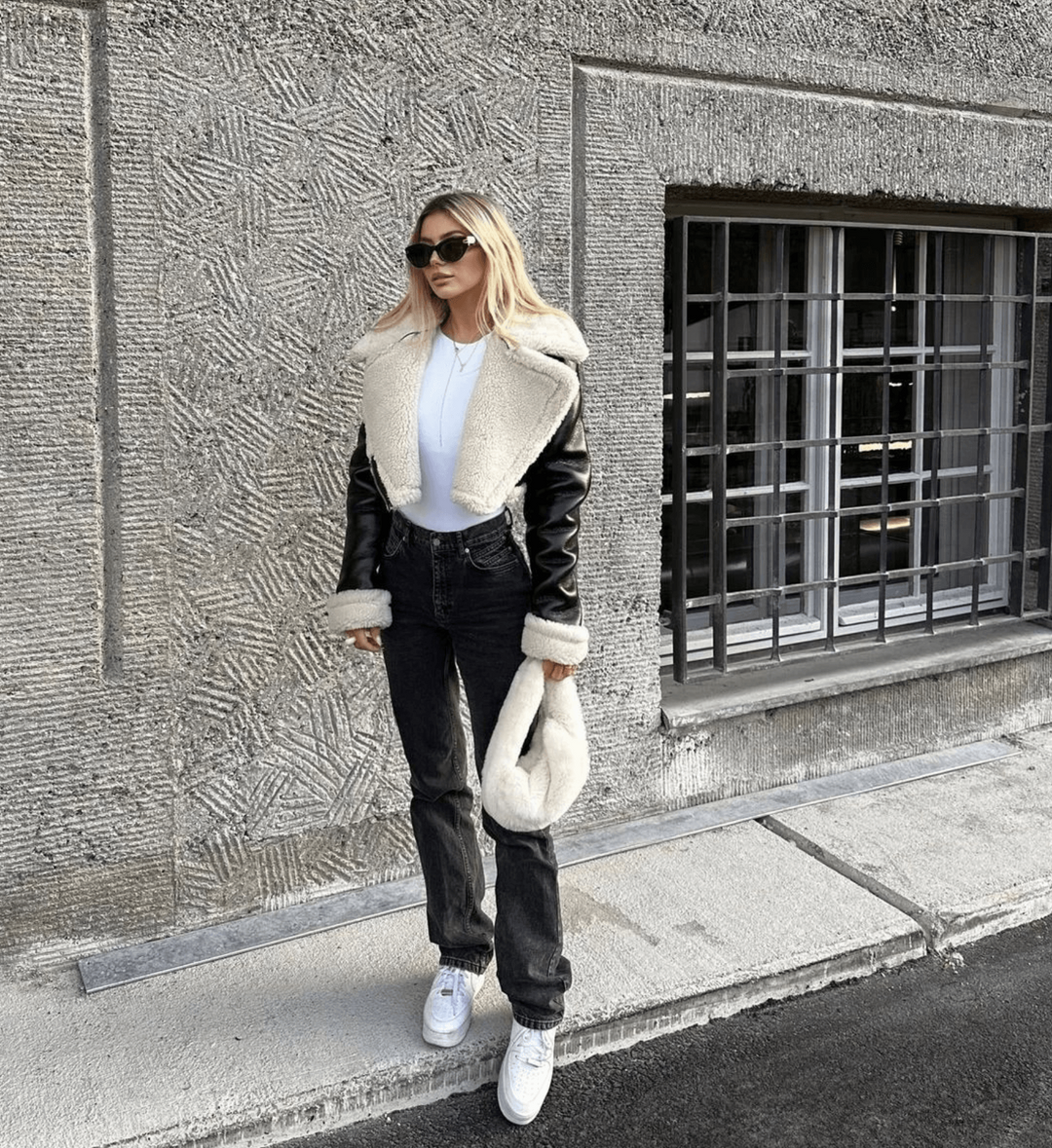 Women's chic black leather winter jacket with cozy fur trim, elegant for cold weather fashion.