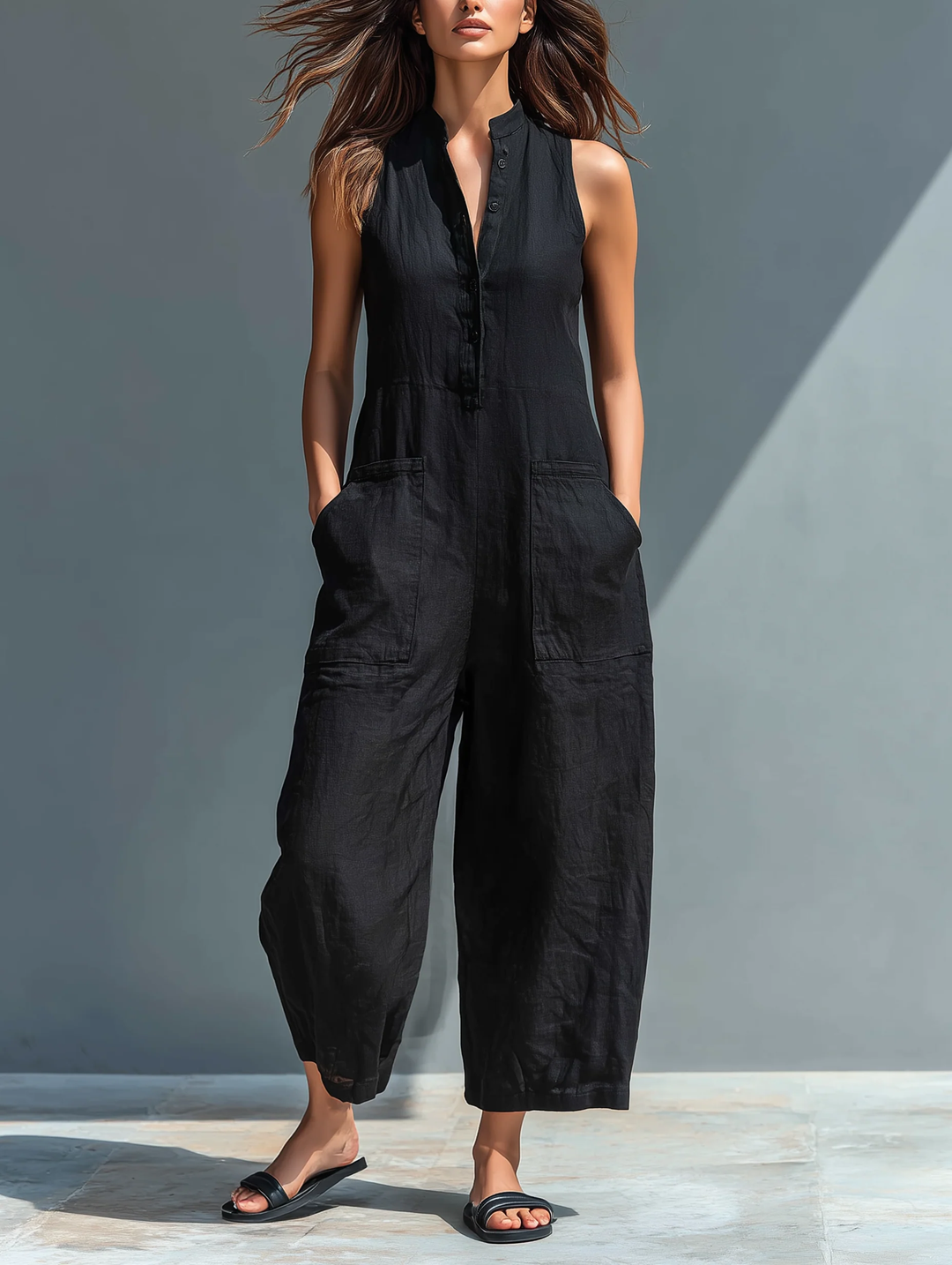Women's chic black sleeveless jumpsuit with a loose, comfortable fit, featuring a stand collar & button-up detail.
