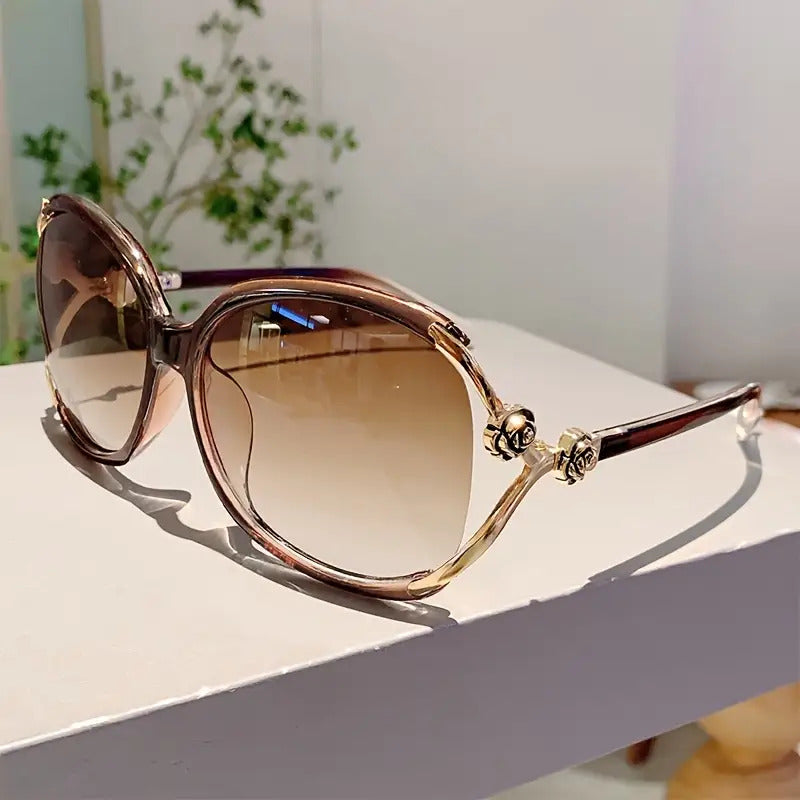 Chic women's oversized gradient sunglasses with subtle rose detail, offering style & UV protection.
