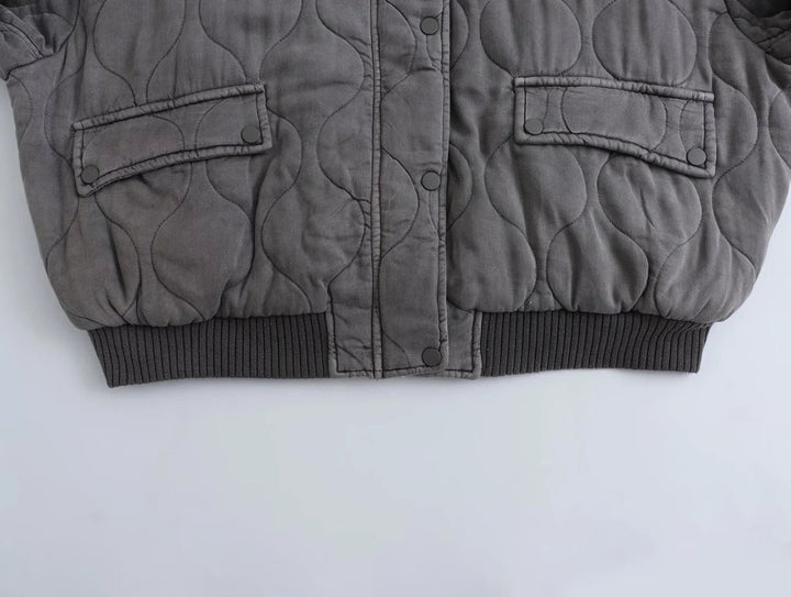 Fashionable women's quilted bomber jacket with intricate quilting. Warm, chic outerwear for winter style.