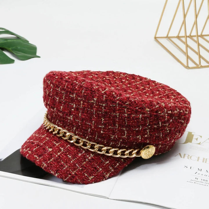 Stylish cotton tweed women's cap with a striking gold chain, a modern chic accessory.