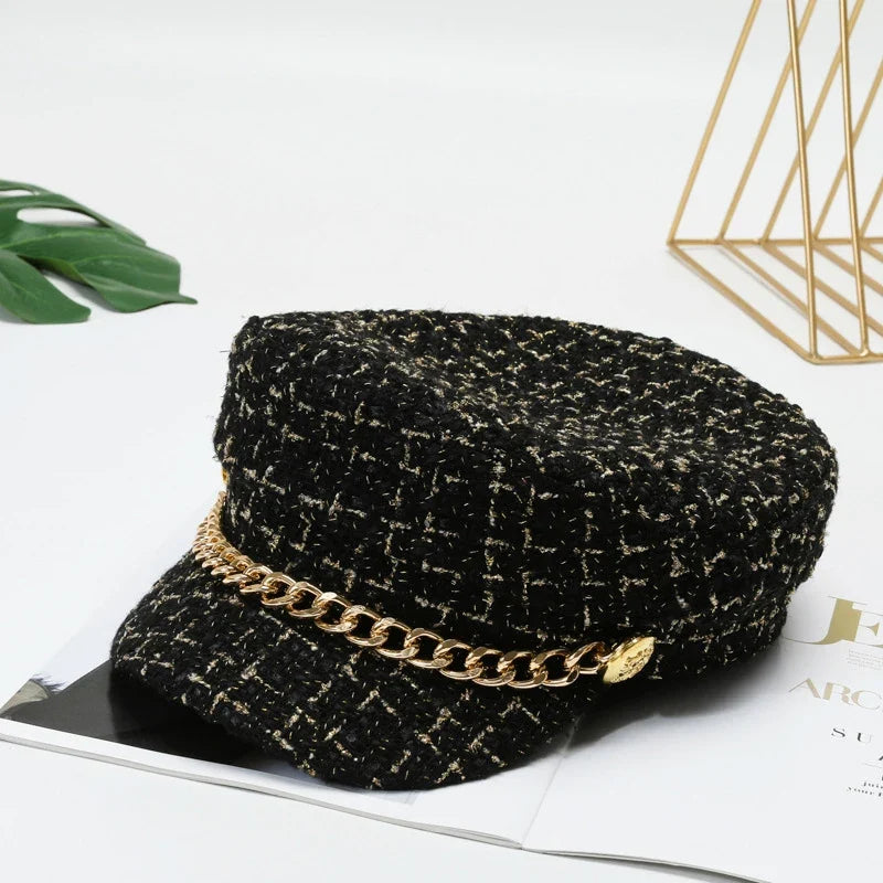 Fashionable women's cotton tweed cap with a decorative gold chain, a smart statement piece.
