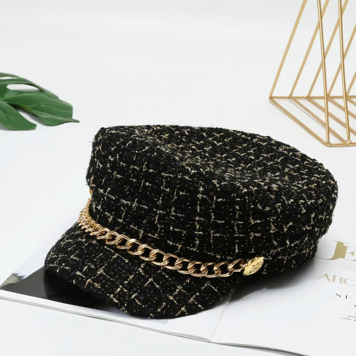 Fashionable women's cotton tweed cap with a decorative gold chain, a smart statement piece.