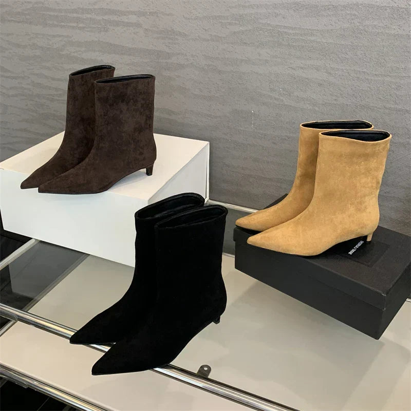 Elegant women's pointed toe suede ankle boots with a low heel. Perfect for autumn fashion and chic winter style.