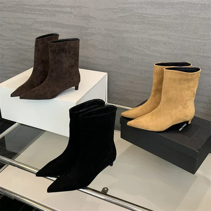 Elegant women's pointed toe suede ankle boots with a low heel. Perfect for autumn fashion and chic winter style.