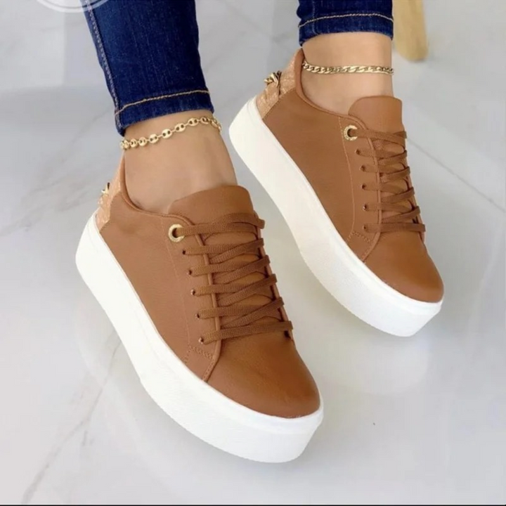 Fashionable white leather sneakers for women, designed with a unique metal chain accent for a trendy & comfortable look.