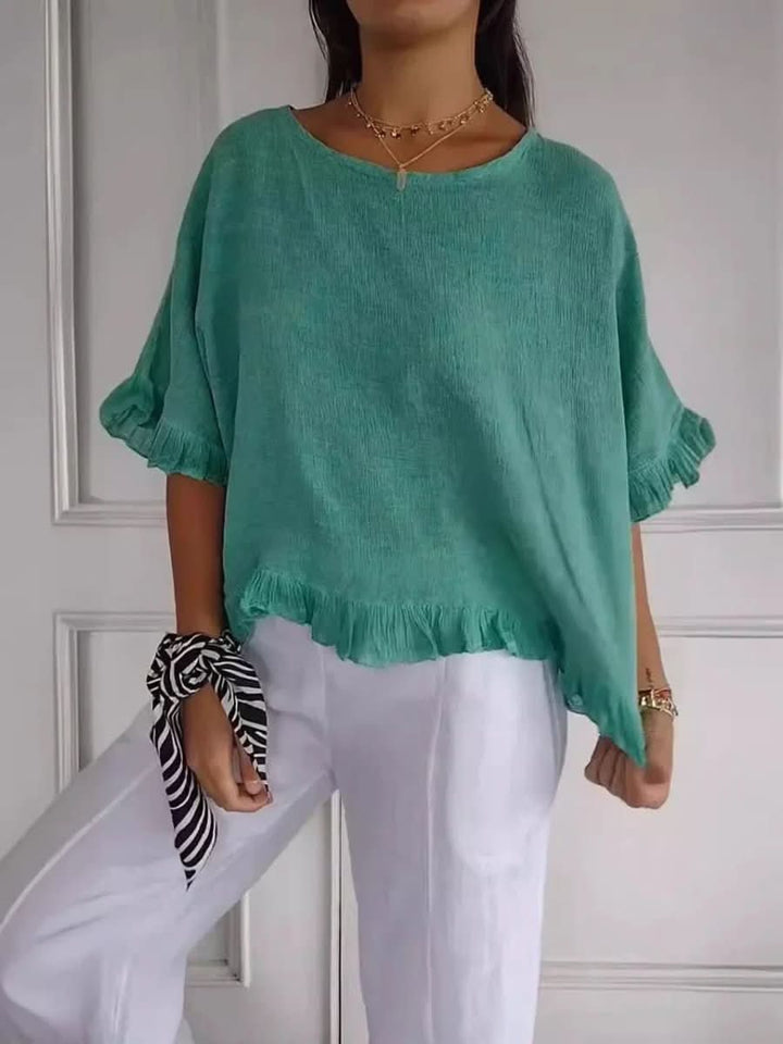 Elegant women's blouse with delicate ruffles and a flattering cut, suitable for chic everyday fashion.