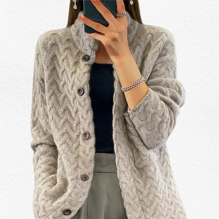 Close-up of a women's chunky cable pattern cardigan, showcasing its textured design and button detail.